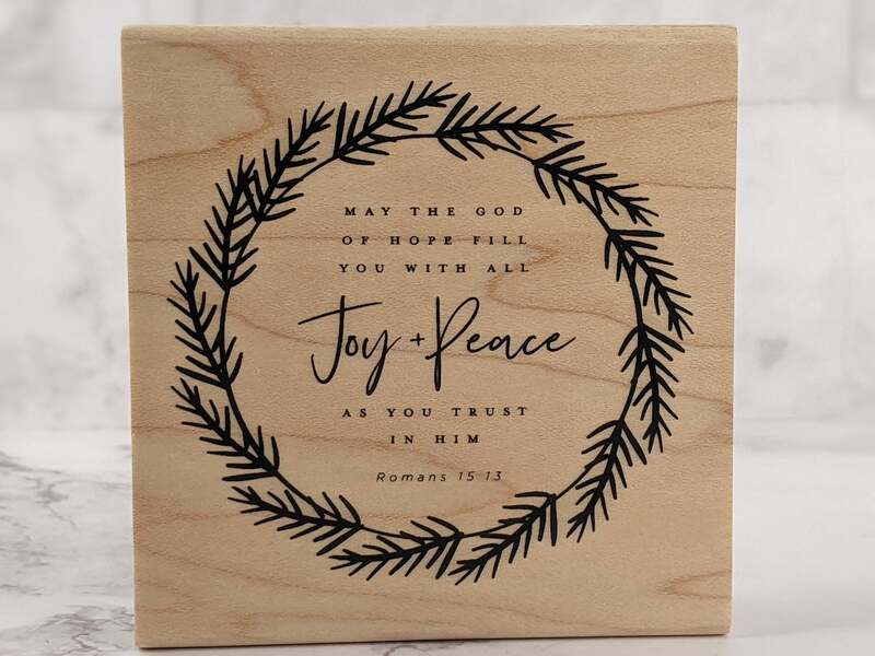 A rubber stamp with a Bible verse about the God of Hope.